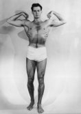 A muscular young man flexes his biceps, circa 1930. (Photo by FPG/Hulton Archive/Getty Images)